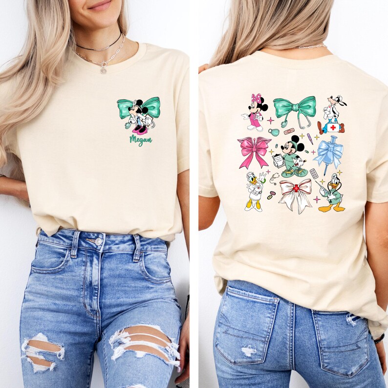 May include: Cream-colored t-shirt featuring a front and back design. The front displays a Minnie Mouse and Mickey Mouse graphic with a teal bow and the name "Megan". The back showcases various cartoon characters with bows and medical-themed elements.