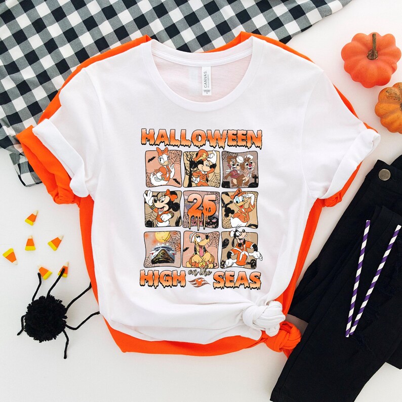 May include: White t-shirt with a graphic of Mickey Mouse and other Disney characters celebrating Halloween on the high seas. The text "Halloween on the High Seas" is printed on the shirt.
