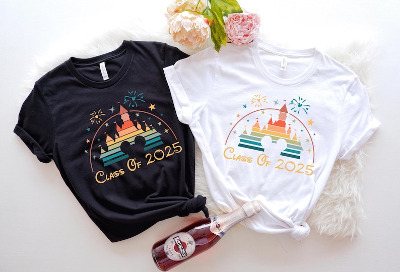 May include: Two t-shirts with a retro rainbow design of Cinderella's castle and the text "Class of 2025". One shirt is black and the other is white.