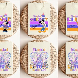 May include: Six different t-shirt designs featuring various Disney characters celebrating Disneyland's 70th anniversary. The designs include Mickey Mouse, Minnie Mouse, Pluto, and a castle with fireworks.