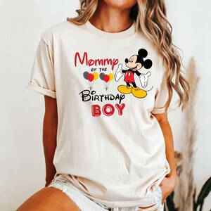 May include: A white t-shirt with the text "Mommy of the Birthday Boy" and a cartoon image of Mickey Mouse holding balloons.
