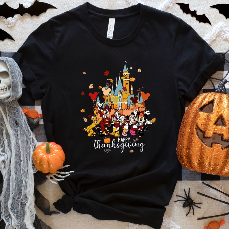 May include: Black t-shirt with a colorful illustration of Mickey Mouse and friends in front of the Disney castle. The text "Happy Thanksgiving" is printed below the illustration.