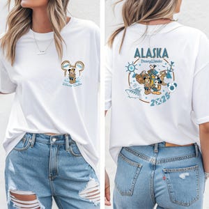 May include: White t-shirt featuring a Mickey Mouse graphic with the text "Mom 2025 Disney Cruise" on the front. The back of the shirt displays "Alaska Disney Wonder 2025" with cartoon characters and nautical elements.