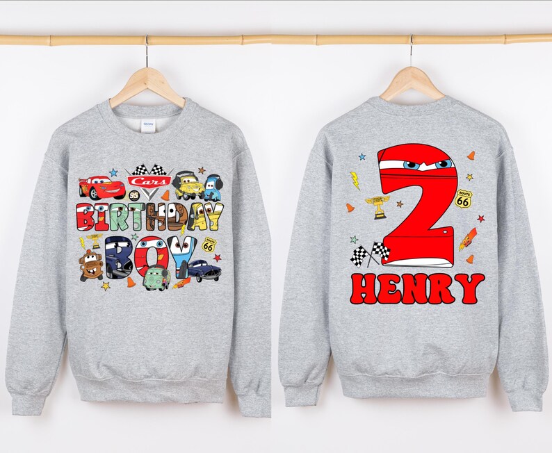 May include: Gray sweatshirt with a Cars birthday boy design on the front and a red number 2 with the name Henry on the back.
