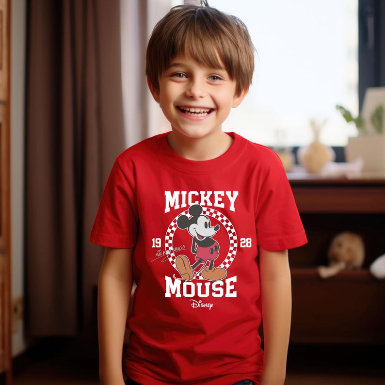 May include: Red short-sleeved t-shirt with a white graphic of Mickey Mouse in a checkered circle. The graphic includes the text "Mickey Mouse" and "1928".