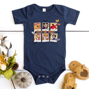 Op de afbeelding: Een donkerblauwe baby romper met een afbeelding van Mickey Mouse en andere Disney-figuren in Halloween-kostuums. De romper heeft de tekst "Trick or Treat" erop gedrukt.
