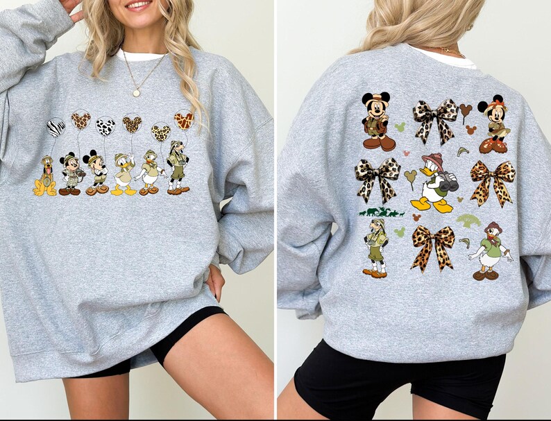 May include: Gray sweatshirt with a print of Disney characters wearing safari outfits and holding balloons. The characters include Mickey Mouse, Minnie Mouse, Donald Duck, Goofy, and Pluto. The print also includes bows and hearts.