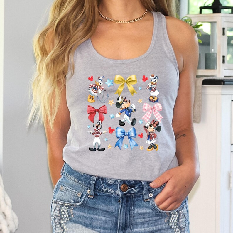 May include: A gray tank top with a colorful print of Mickey Mouse and friends wearing different outfits and holding bows. The print includes red, blue, yellow, and white bows.
