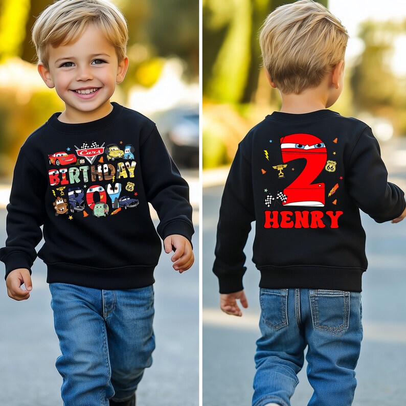 May include: Black sweatshirt with a Cars themed birthday design on the front and a red number 2 with the name Henry on the back. The sweatshirt is being worn by a young child.