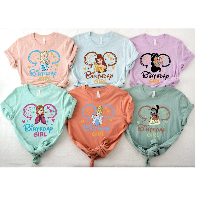May include: Six different t-shirts featuring Disney princesses with the text "Be Birthday Girl" on each shirt. The princesses featured are Elsa, Belle, Tiana, Anna, Cinderella, and Tiana.