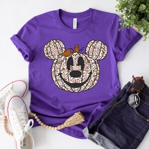 May include: Purple short-sleeved t-shirt with a floral print pumpkin Mickey Mouse design.