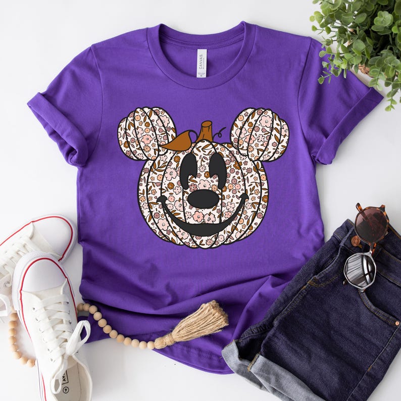 May include: Purple short-sleeved t-shirt with a floral print pumpkin Mickey Mouse design.