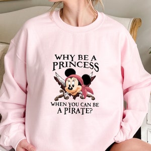 May include: Pink sweatshirt with a black graphic of Mickey Mouse dressed as a pirate with the text "Why be a princess when you can be a pirate?"
