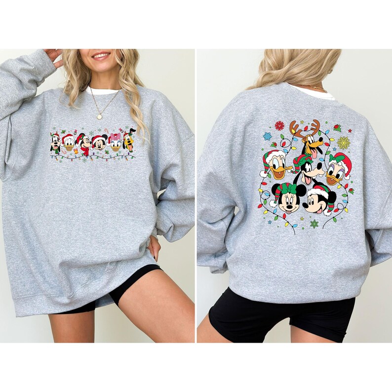 May include: A light gray sweatshirt featuring a festive design with Disney characters wearing Santa hats and surrounded by Christmas lights. The front design includes Mickey, Minnie, Donald, Daisy, Goofy, and Pluto. The back design features Mickey, Minnie, Donald, Goofy, and Pluto.