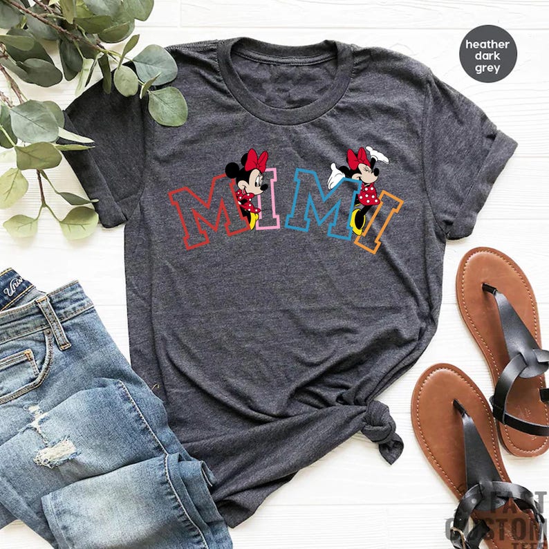 May include: A heather dark grey t-shirt with a colorful "MIMI" graphic featuring two cartoon Minnie Mouse characters.