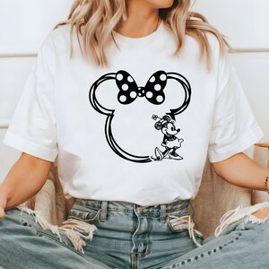 May include: White t-shirt with a black and white graphic of Minnie Mouse's head with a bow and Minnie Mouse standing in the outline of her head.
