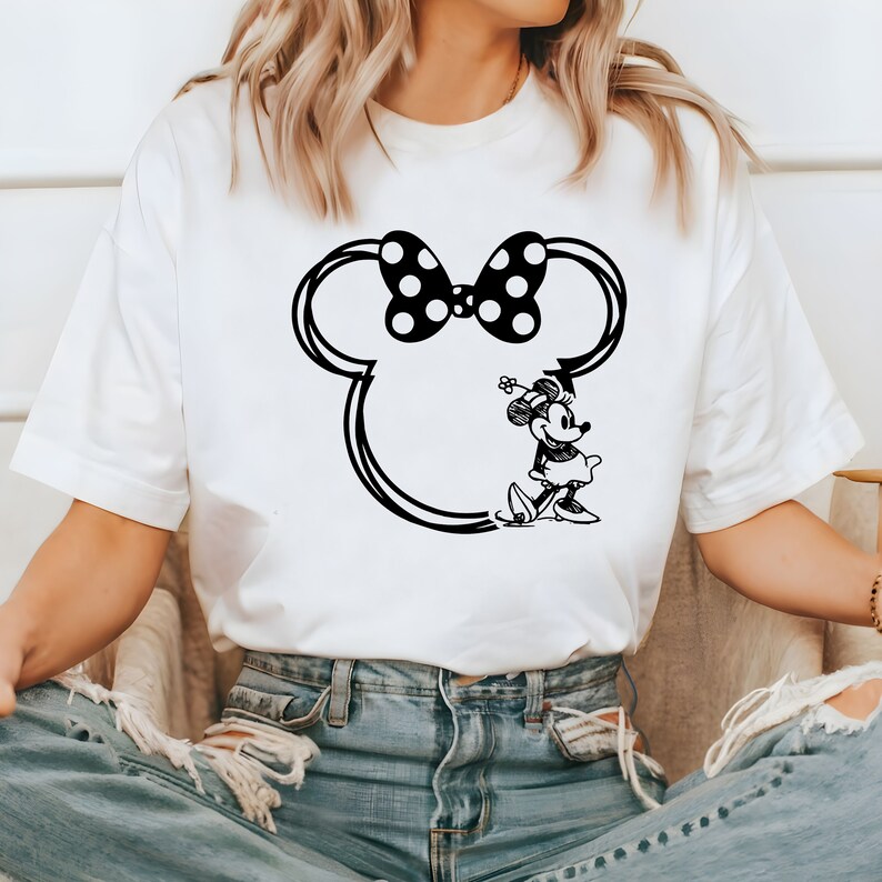 May include: White t-shirt with a black and white graphic of Minnie Mouse's head with a bow and Minnie Mouse standing in the outline of her head.