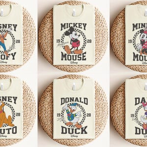 May include: Six beige t-shirts with a vintage-style Disney character graphic on each. The characters are Goofy, Mickey Mouse, Minnie Mouse, Pluto, Donald Duck, and Daisy Duck. Each graphic features a checkered background and the character's name in a bold font.
