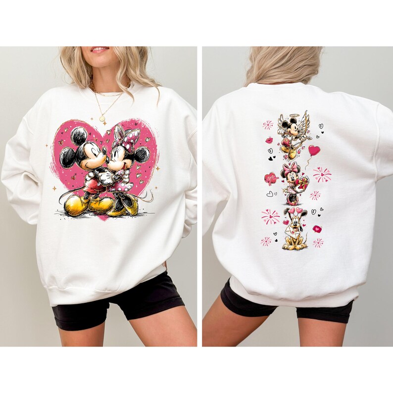 May include: White sweatshirt featuring Mickey and Minnie Mouse embracing within a pink heart on the front. The back displays a vertical arrangement of Disney characters with hearts and fireworks. A cozy, long-sleeved top for Disney fans.