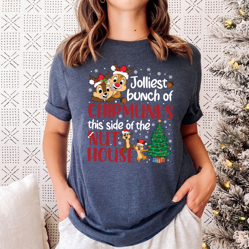 May include: A navy blue t-shirt with a Christmas-themed design featuring Chipmunks from the movie "Alvin and the Chipmunks". The design includes the text "Jolliest bunch of Chipmunks this side of the Nut House".