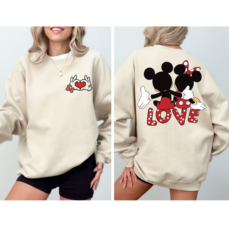 May include: A beige sweatshirt with a red heart and Mickey Mouse and Minnie Mouse holding hands on the front. The back of the sweatshirt has Mickey Mouse and Minnie Mouse holding hands with the word "LOVE" in red letters with white polka dots.