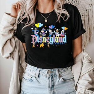 May include: Black t-shirt featuring a colourful Disneyland Resort graphic with Mickey Mouse, Minnie Mouse, Donald Duck, Goofy and Pluto. The graphic includes the text "Disneyland Resort" in a rainbow font.