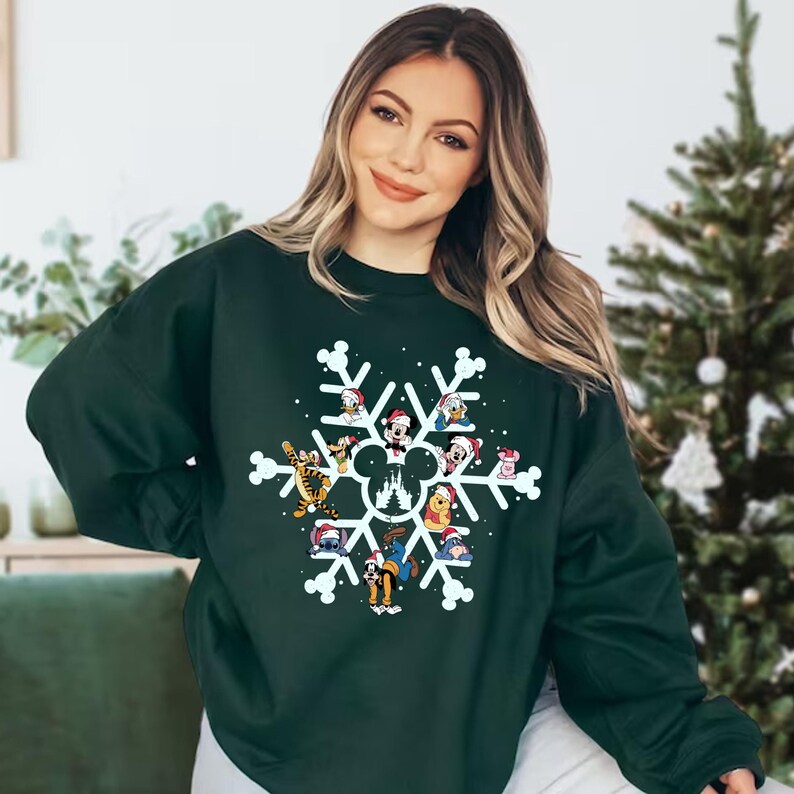 May include: A dark green sweatshirt with a white snowflake design featuring various Disney characters wearing Santa hats. The characters include Mickey Mouse, Minnie Mouse, Donald Duck, Goofy, Pluto, and others.