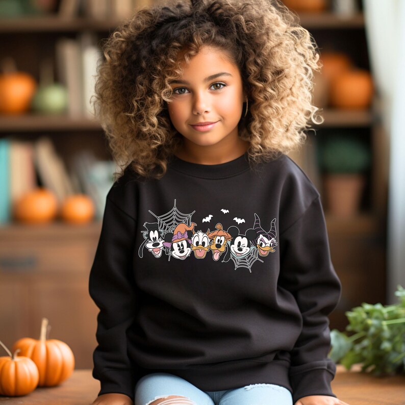 Puede incluir: Una sudadera negra con un gr&aacute;fico de Mickey Mouse y sus amigos disfrazados para Halloween. El gr&aacute;fico incluye una telara&ntilde;a, murci&eacute;lagos y los personajes Goofy, Minnie Mouse, Donald Duck, Pluto, Mickey Mouse y una bruja.