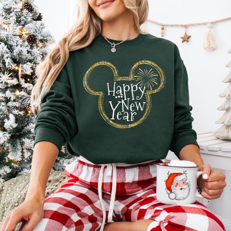 May include: A green sweatshirt with a gold glitter Mickey Mouse head design and the text "Happy New Year".