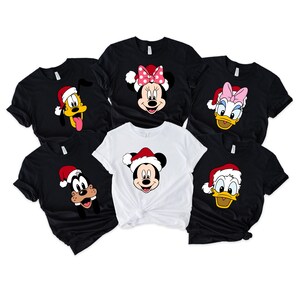 May include: Six black and white t-shirts with different Disney characters wearing Santa hats. The characters are Mickey Mouse, Minnie Mouse, Goofy, and Donald Duck.