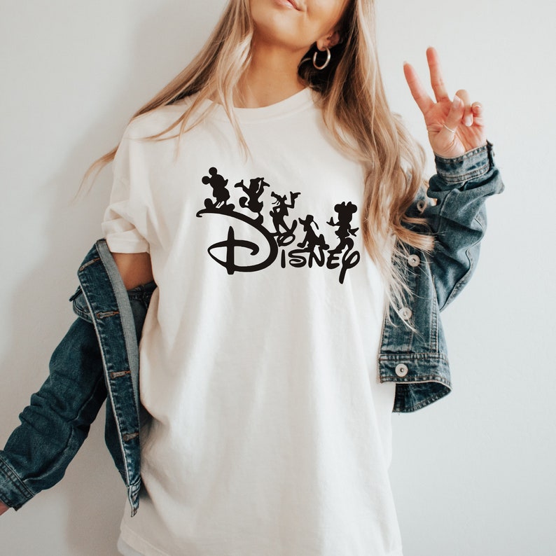 May include: A white t-shirt with a black silhouette of Mickey Mouse and other Disney characters above the word "DISNEY".
