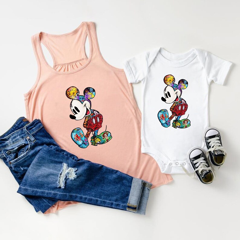 Puede incluir: Una camiseta de tirantes rosa y un body blanco con un gr&aacute;fico de Mickey Mouse colorido. El gr&aacute;fico de Mickey Mouse est&aacute; formado por im&aacute;genes m&aacute;s peque&ntilde;as de personajes de Disney.