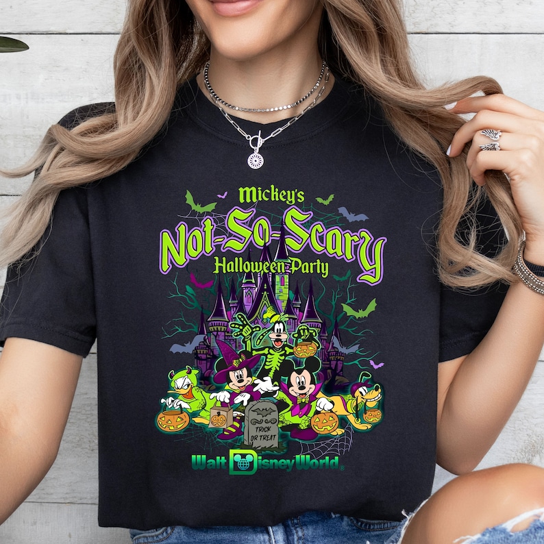 May include: Black t-shirt with a green and purple graphic of Mickey Mouse and friends in front of a castle. The text "Mickey's Not-So-Scary Halloween Party" is above the graphic. The text "Walt Disney World" is below the graphic.