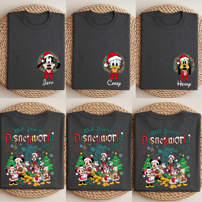 Op de afbeelding: Donkergrijze t-shirts met Disney-personages in kerstmutsen en kransen. E&eacute;n shirt toont Goofy met de naam "Jeff", een ander Donald Duck met "Casey", en een derde Pluto met "Henry". Andere shirts tonen een Disney World-ontwerp.