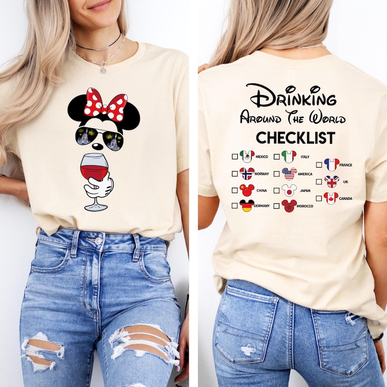 Puede incluir: Una camiseta beige con un gr&aacute;fico de un rat&oacute;n de dibujos animados con gafas de sol y sosteniendo una copa de vino. La parte posterior de la camiseta tiene el texto "Drinking Around the World Checklist" con una lista de pa&iacute;ses y banderas.