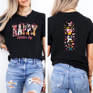 May include: Black t-shirt with a Valentine's Day design. The front features the word "HAPPY" with Disney characters and "Valentine's Day" in pink. The back has a vertical design with Disney characters, hearts, and bows.