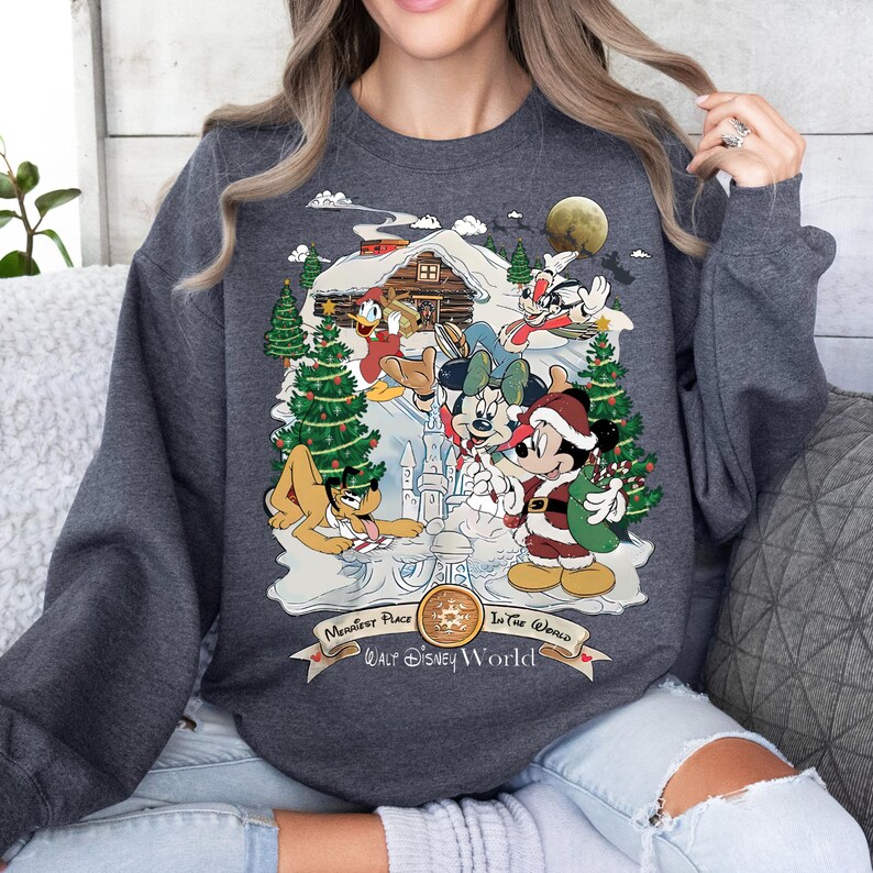 Pu&ograve; includere: Una felpa grigia con una scena natalizia con Topolino, Minnie Mouse, Pluto, Paperino e Pippo. La scena &egrave; ambientata in un paese delle meraviglie invernale innevato con una capanna, un albero di Natale e un pupazzo di neve. Il testo "Happiest Place On Earth" e "Walt Disney World" &egrave; stampato sulla felpa.