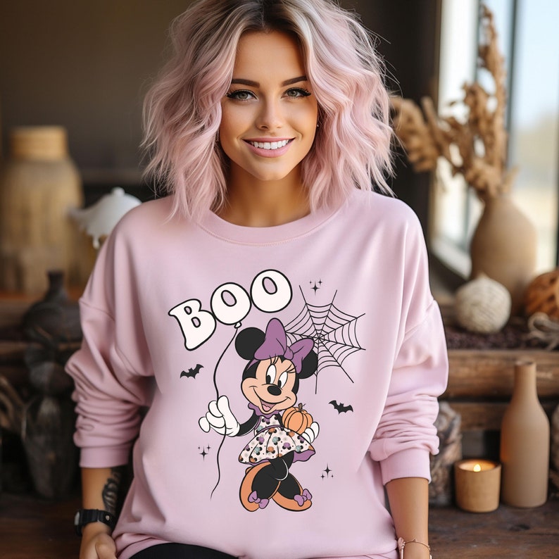May include: Pink sweatshirt with a graphic of Minnie Mouse holding a pumpkin and a balloon that says "BOO".