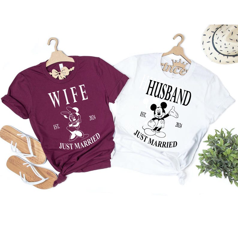 May include: Two t-shirts, one burgundy and one white, with a Mickey Mouse and Minnie Mouse graphic. The burgundy shirt says "Wife" and the white shirt says "Husband". Both shirts say "Just Married" and "Est. 2024".