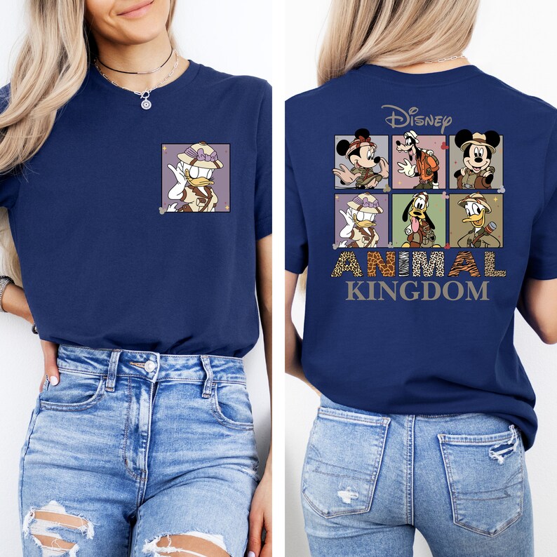 Pu&ograve; includere: Una maglietta blu navy con una grafica di personaggi Disney vestiti con abiti da safari. Il testo "Disney Animal Kingdom" &egrave; stampato sul retro della maglietta.