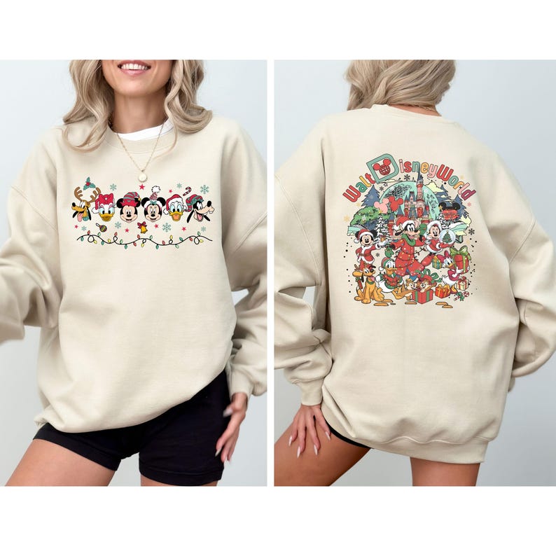 Op de afbeelding: Beige sweatshirt met een feestelijk Disney-ontwerp. De voorkant toont Mickey Mouse, Minnie Mouse, Donald Duck en Goofy in vakantiekleding. De achterkant toont een kleurrijke illustratie van Disney-personages en de tekst "Walt Disney World".