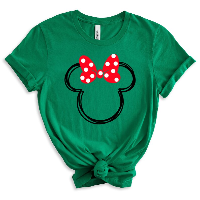 May include: Green t-shirt with a black outline of Mickey Mouse's head and a red bow with white polka dots.