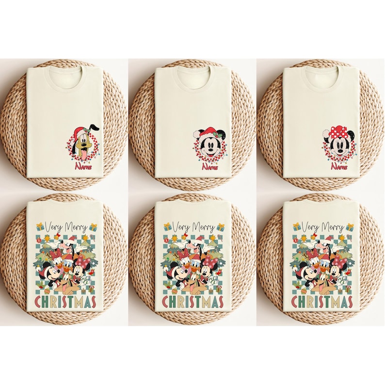 May include: Six cream-colored t-shirts with Christmas-themed designs. The shirts feature images of Disney characters like Pluto, Mickey, and Minnie Mouse, along with the text "Very Merry CHRISTMAS". Each shirt is folded and placed on a woven mat.
