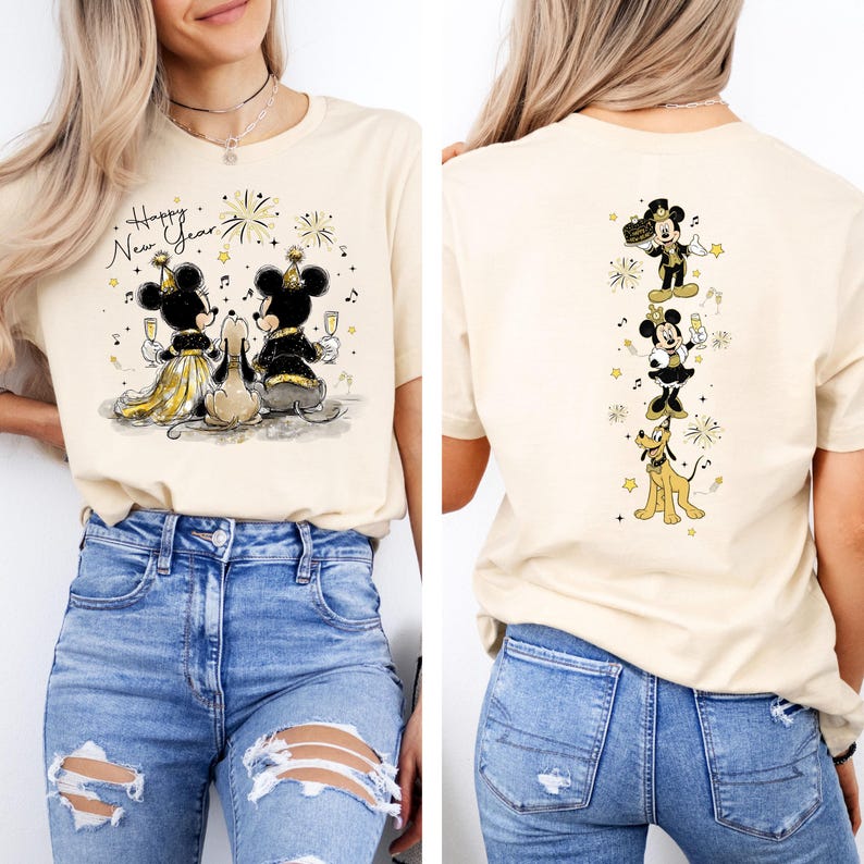 Puede incluir: Camiseta beige con un dise&ntilde;o de A&ntilde;o Nuevo con Mickey y Minnie Mouse, y Pluto. La parte delantera muestra a los personajes brindando con champ&aacute;n, con el texto "Happy New Year". La parte trasera muestra a los personajes en l&iacute;nea vertical.