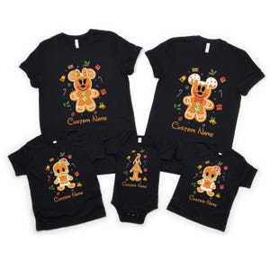 May include: A set of four black t-shirts featuring a gingerbread man design with the text "Custom Name". The shirts are in different sizes for adults and children.