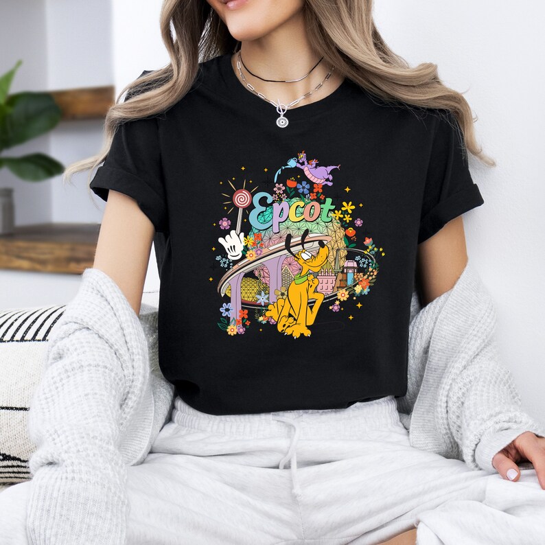 May include: Black t-shirt with a colorful graphic of Pluto, the Spaceship Earth, and the text "Epcot" on a black background.