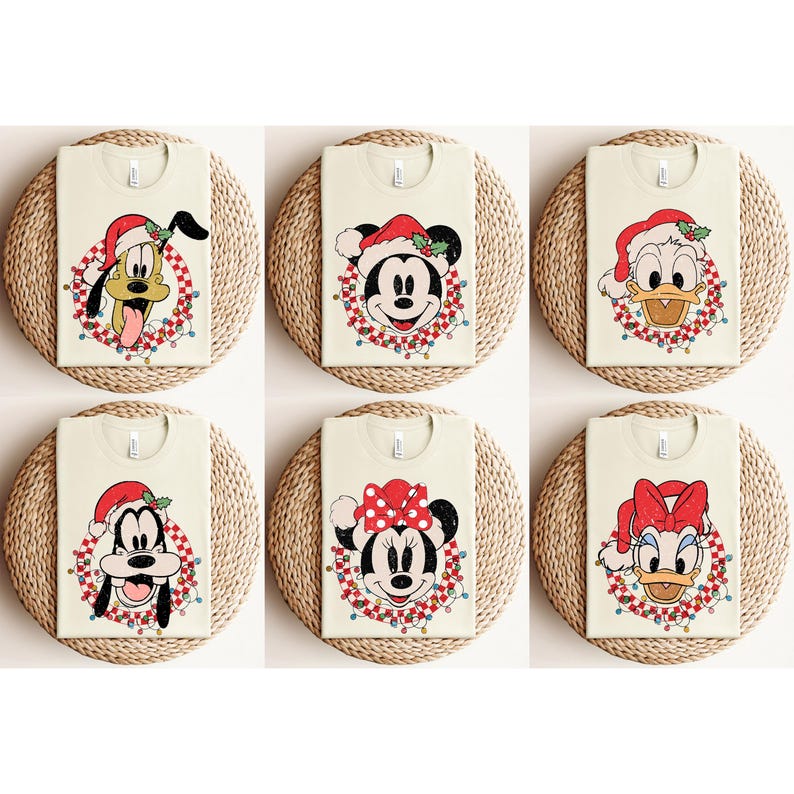May include: Six white t-shirts with different Christmas-themed Disney character designs. The characters include Mickey Mouse, Minnie Mouse, Donald Duck, Daisy Duck, Pluto, and Goofy. Each character is wearing a Santa hat and is surrounded by a red and white wreath with Christmas lights.