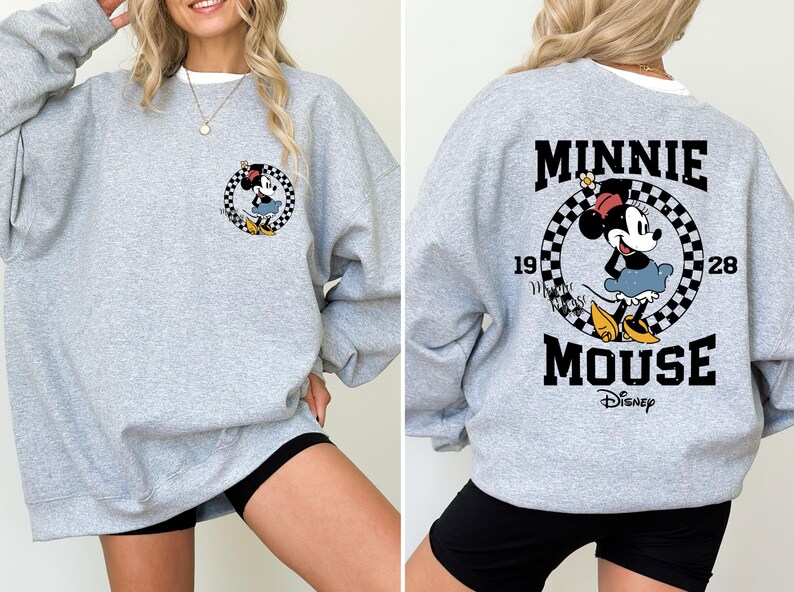 May include: Gray sweatshirt with a black and white checkered circle graphic featuring Minnie Mouse. The text "Minnie Mouse" and "Disney" are printed below the graphic.