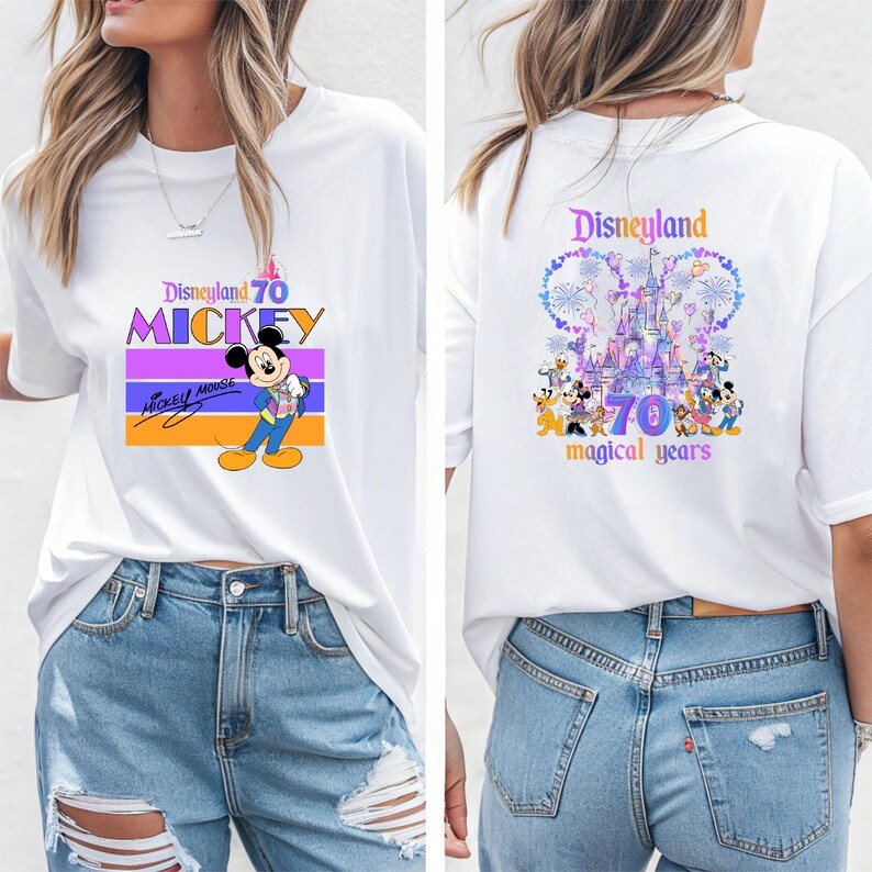 May include: White t-shirt with a graphic of Mickey Mouse and the text "Disneyland 70 Mickey" on the front. The back of the shirt features a graphic of the Disneyland castle with fireworks and the text "Disneyland 70 magical years".