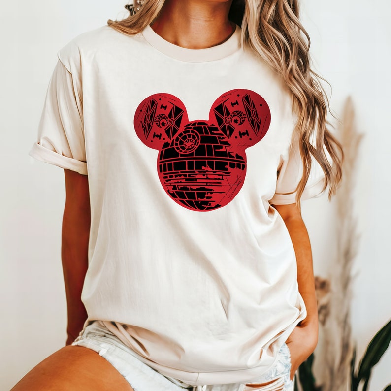 May include: A white t-shirt with a red Mickey Mouse head design. The head is made up of the Death Star from Star Wars.
